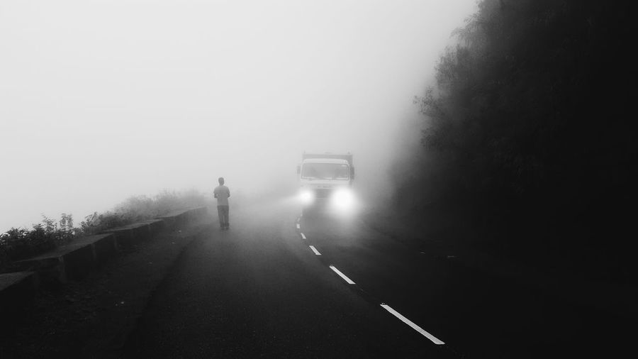 Cars on road against sky during foggy weather