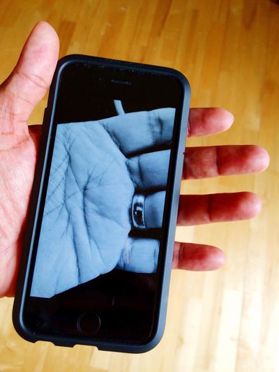 High angle view of human hand holding smart phone