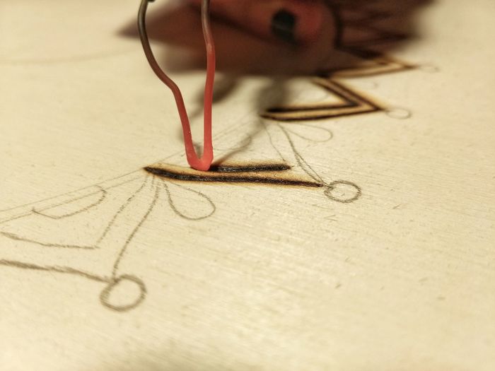Cropped finger of woman making design on fabric