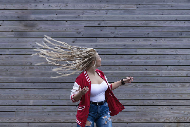 Blonde woman with dreadlocks wagging her hair