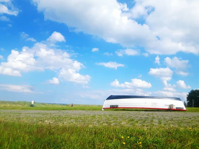Scenic view of grassy field against sky