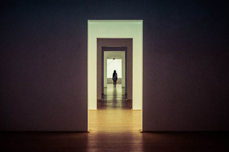 Rear view of woman standing in corridor 