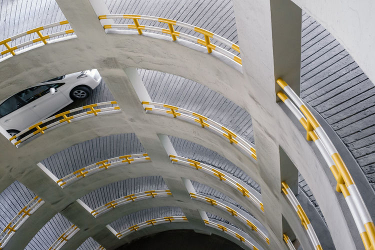Car climbing up a slope of spiral path for parking space
