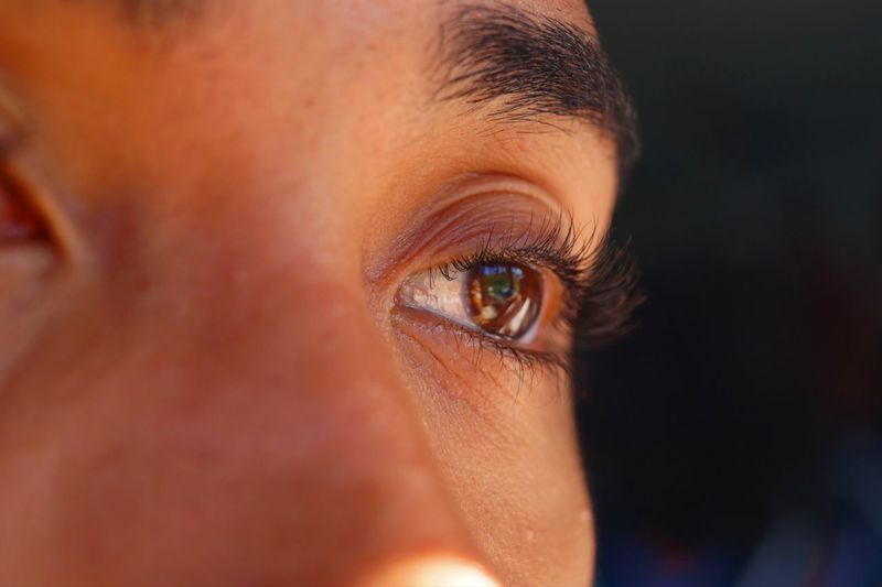 Close-up of light brown eye of boy looking away