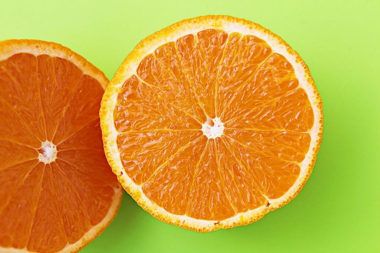 Close-up of lemon slice against orange background