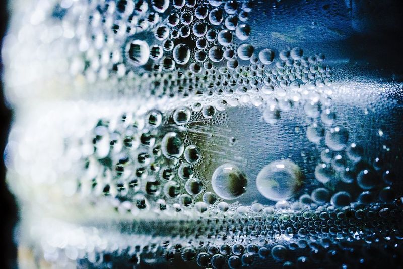 EXTREME CLOSE UP OF WATER DROPS ON GLASS
