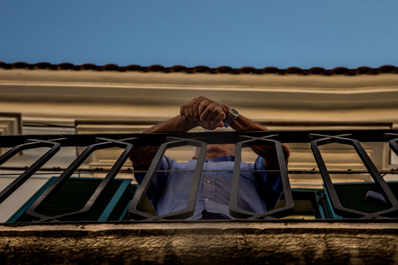 Low angle view of senior man standing in balcony