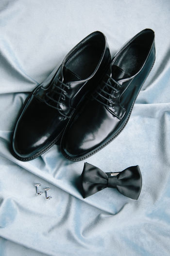 Groom accessories. shoes, bow tie, and cufflinks.