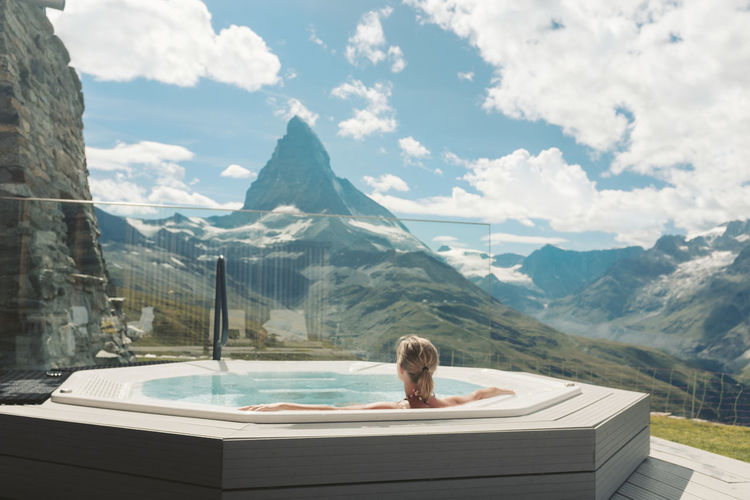Woman in hot tub looking at mountains