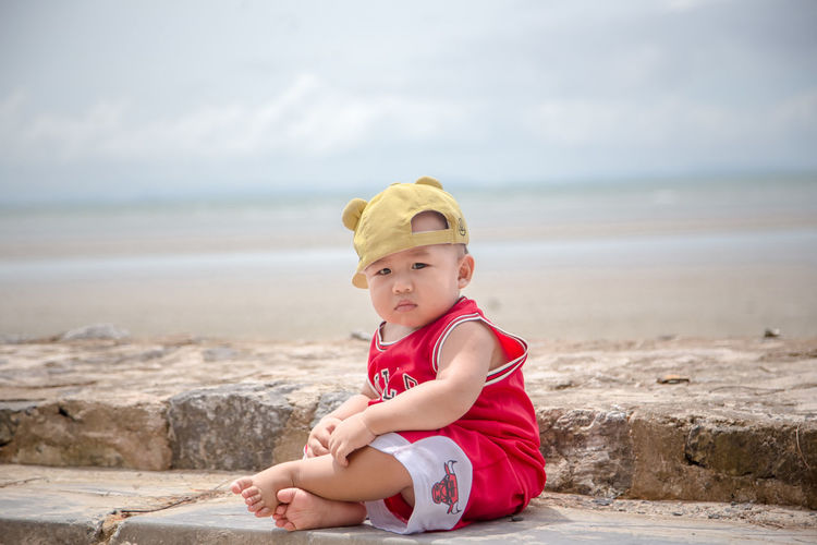 Portrait of cute boy sitting on beach