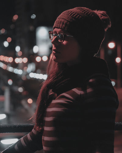 Woman standing in illuminated city
