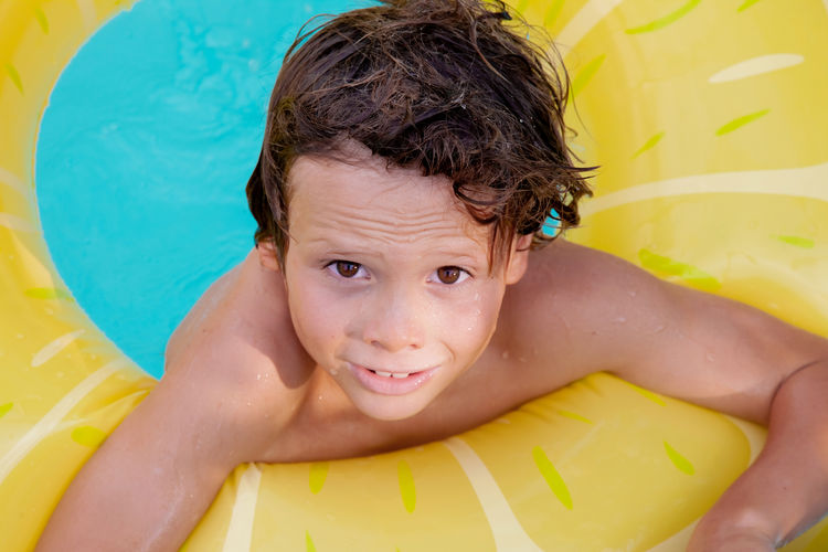 Happy holiday time. boy having fun in pool with float. face emotions. summer vibes