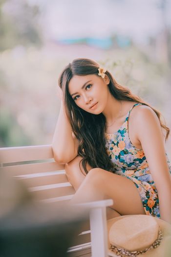 Portrait of beautiful young woman sitting outdoors
