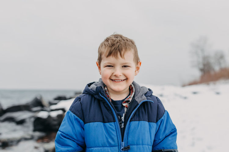 Portrait of smiling boy standing in snow