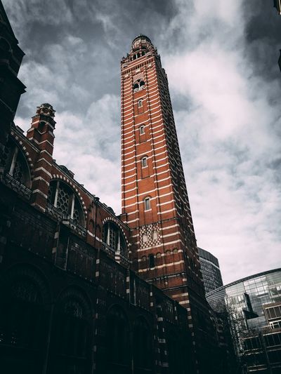 Low angle view of buildings against cloudy sky