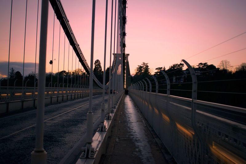 View of suspension bridge against sky during sunset