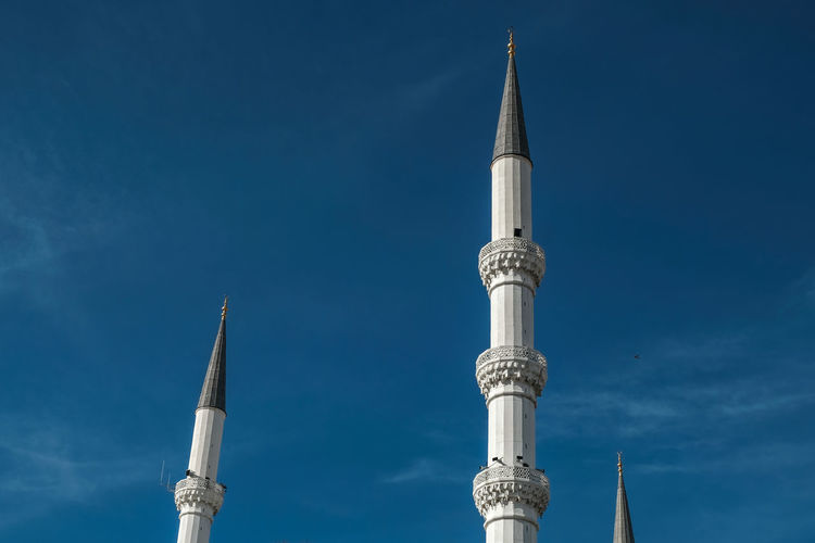 Low angle view of mosque and minaret  against blue sky