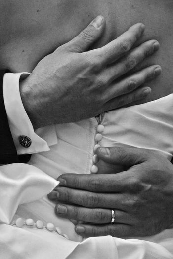 Midsection of bridegroom hugging bride
