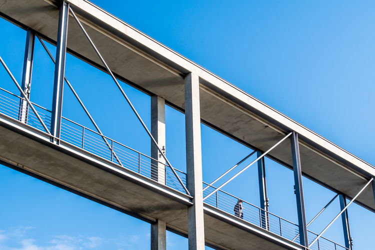 Low angle view of footbridge against blue sky
