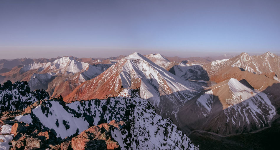 Aerial view of snowcapped mountains against clear sky during winter