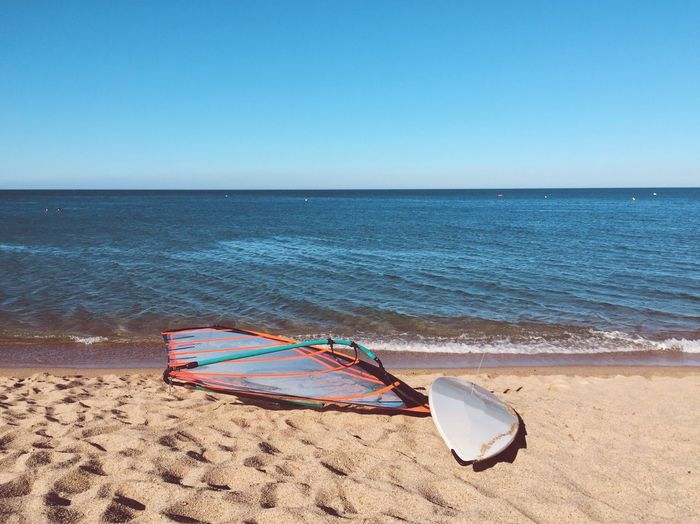 Abandoned windsurfing board on sunny beach