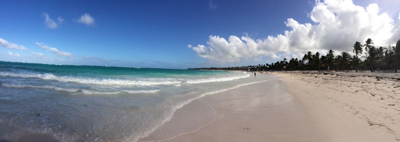 Panoramic view of beach against cloudy blue sky