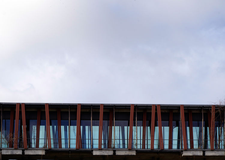 Low angle view of passenger boarding bridge against sky