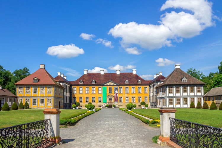 Footpath amidst buildings against sky
