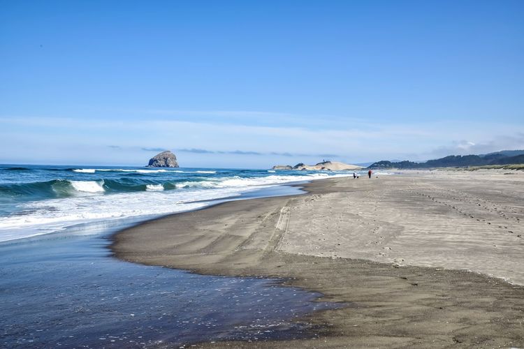 Scenic view of beach against blue sky