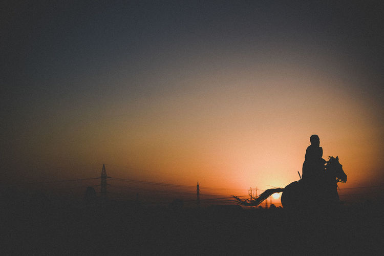 Silhouette of man riding at dusk