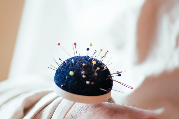 Cropped image of hand with pin cushion