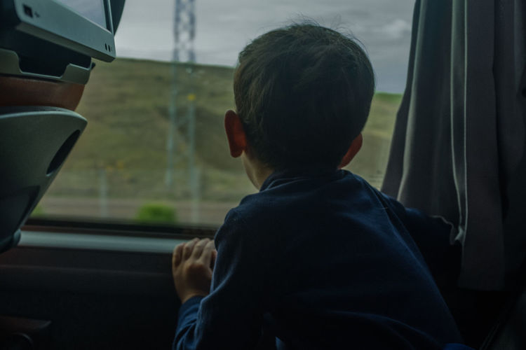 Boy looking through train window