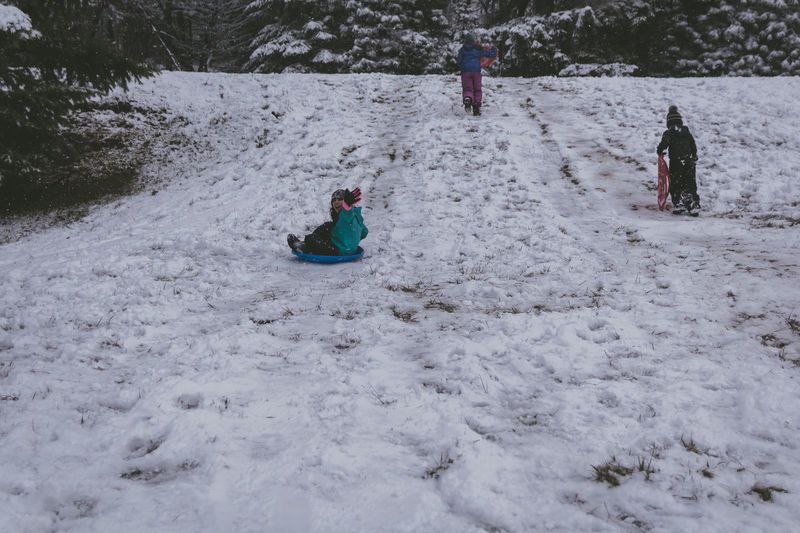 Rear view of children on snow covered land