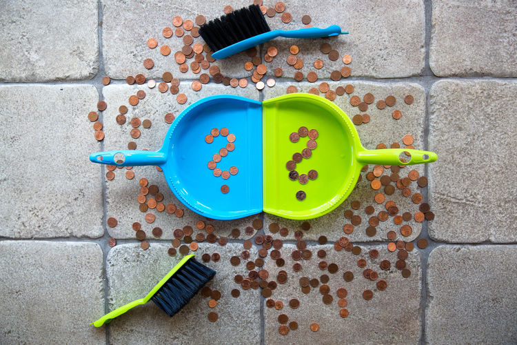 Directly above view of coins in dustpan and scattered flooring