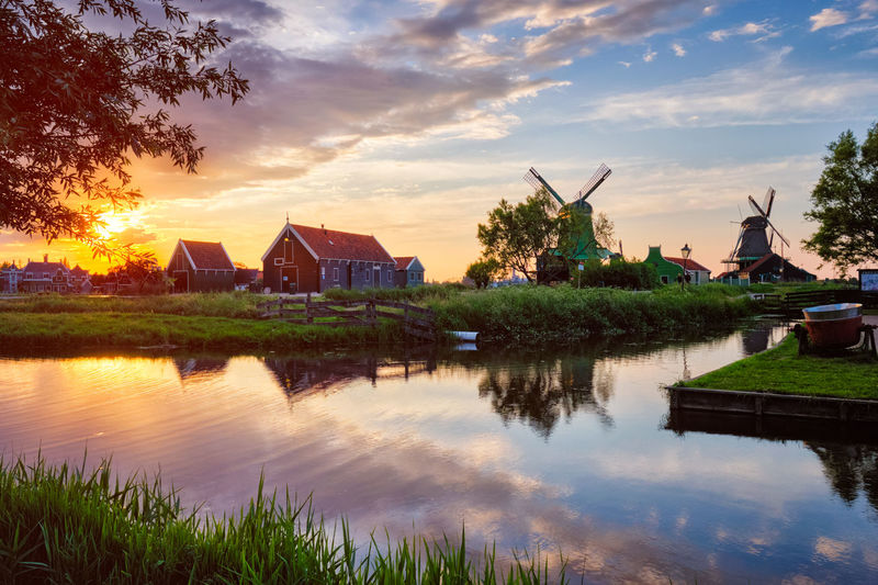 Houses by lake against sky