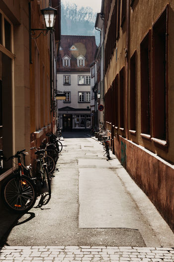 Bicycle parked in alley amidst buildings