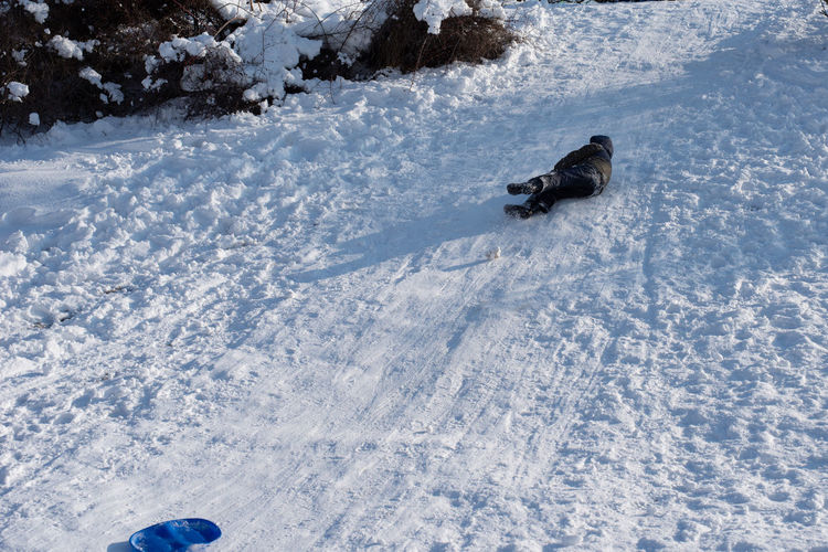 Boy lying on snow mountain