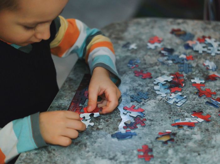 Boy playing puzzle game at table