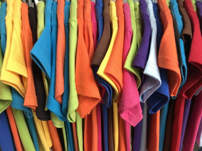 Multi colored clothes hanging on display at store