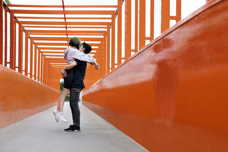 Teenage couple kissing on orange bridge