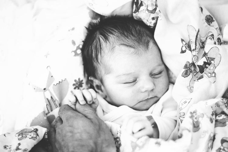 High angle view of person holding baby girl at home