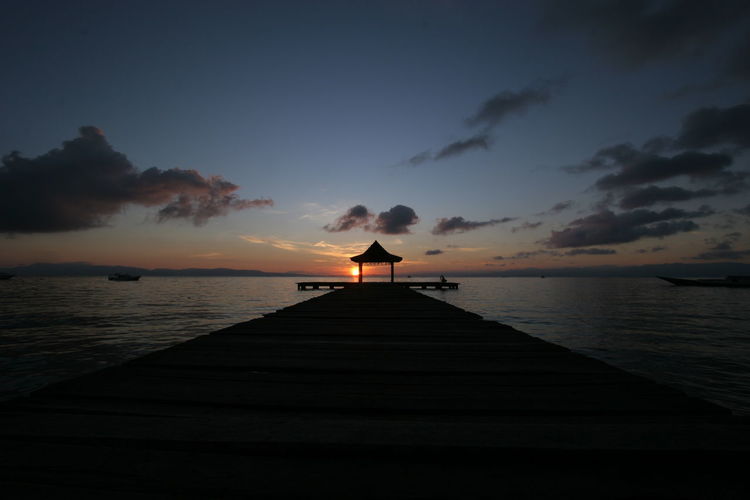 Silhouette pier on sea against sky during sunset