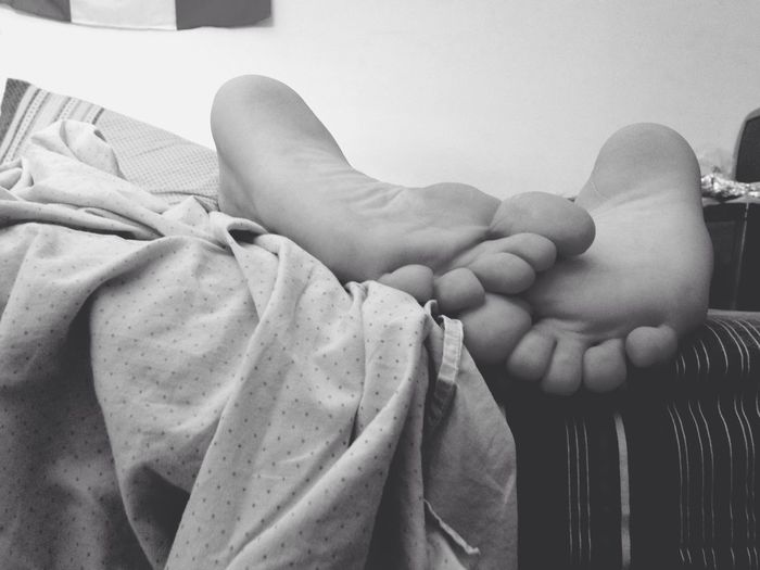Close-up of human feet in bed