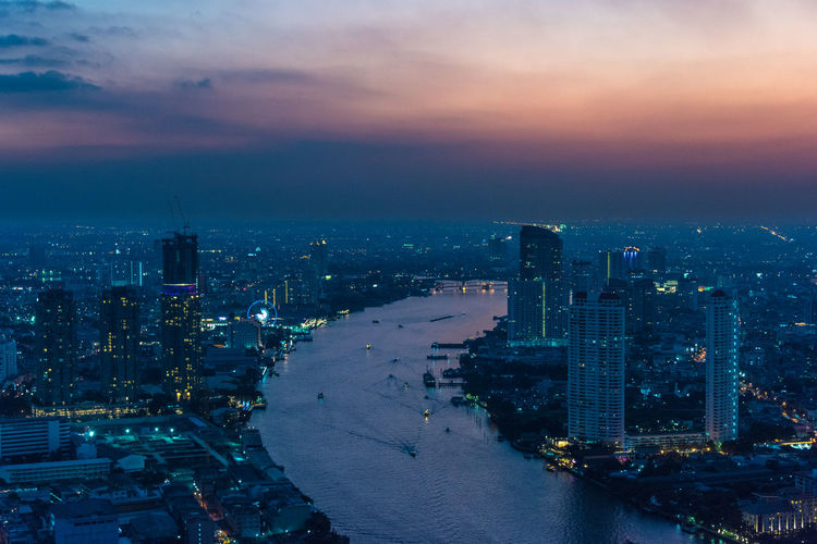Aerial view of bangkok cityscape at dusk with chao phraya river. modern urban background