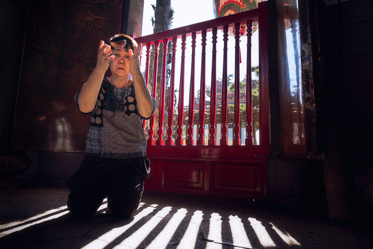 Asian woman is making fortunes in a famous shrine in taiwan. red wood for making fortune 