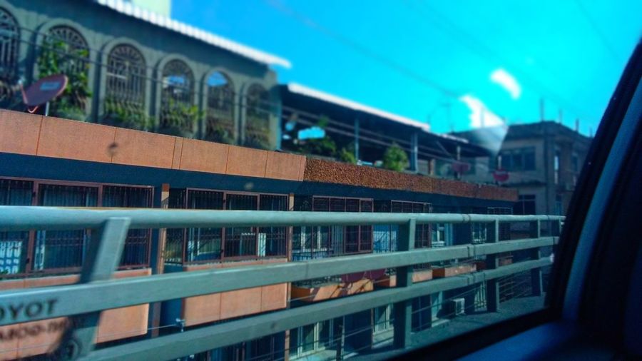 Buildings against blue sky seen from train window