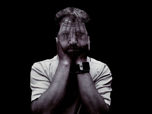 Digital composite image of man covering face with hands