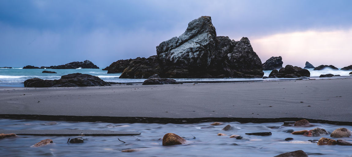 Scenic view of rock formation in sea against sky