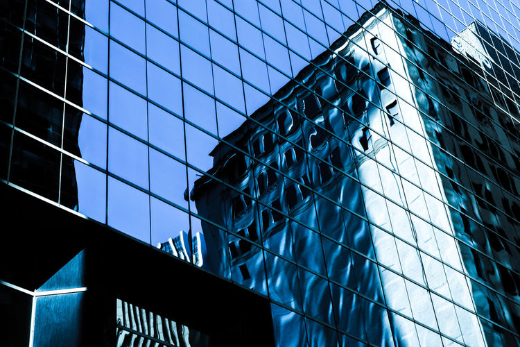 Low angle view of office building with reflection