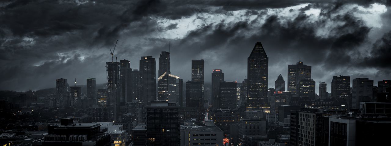 Buildings in city against cloudy sky